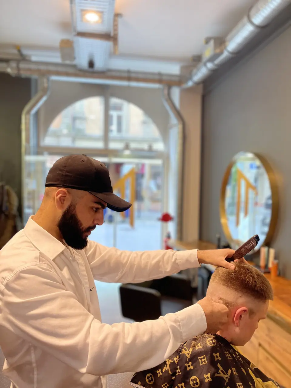 Barber von Studio MN schneidet am Fensterplatz die Konturen
